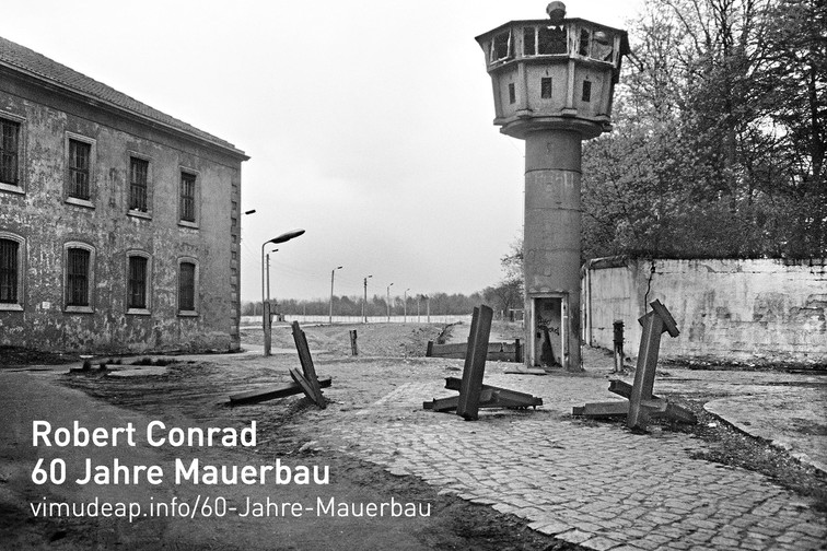 Berliner Mauer auf der Stahnsdorfer Straße an der West-Berliner Exklave Steinstücken, Bereich Teltower Straße (Potsdam Babelsberg), Rote-Kreuz-Straße. Todesstreifen mit Postenturm und Panzersperren, links ehemaliger Verwaltungsbau des Deutschen Roten Kreuzes von 1939, in der DDR durch die Hochschule für Staatsrecht genutzt. Bild 9157