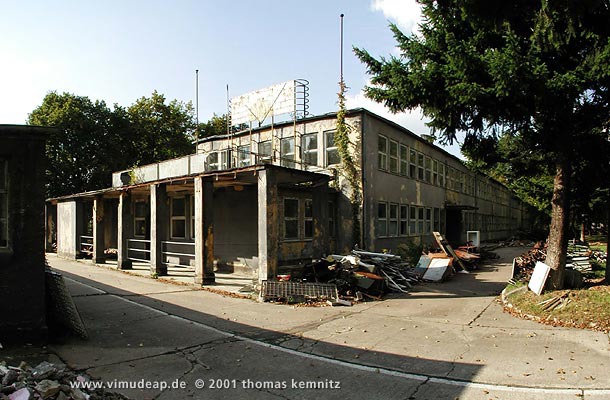 Verwaltungsgebäude. Pförtnerbereich des ehemaligen Verwaltungsgebäudes. Darüber eine Terrasse und das Firmensignet. Rechts der Haupteingang. Verwaltungsgebäude. Pförtnerbereich des ehemaligen Verwaltungsgebäudes. Darüber eine Terrasse und das Firmensignet. Rechts der Haupteingang.
