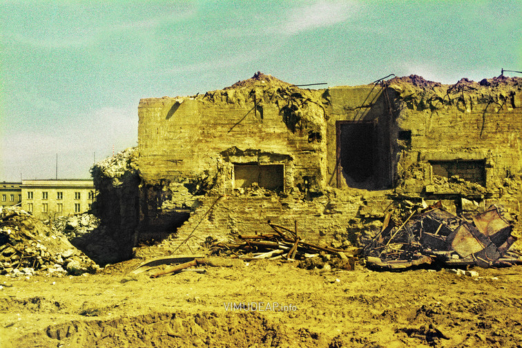 Freigelegter »Kleiner Bunker« der Neuen Reichskanzlei von Westen. Blick nach Osten auf die massive Stahlbetonkonstruktion des freigegrabenen »Kleine Bunkers« der Neuen Reichskanzlei. Die Anlage befand sich ursprünglich südlich des so genannten Ehrenhofes nahe der Präsidialkanzlei an der Voßstraße und war ursprünglich durch einfache, jetzt nicht mehr vorhandene Kellerräume begrenzt. Links im Hintergrund: Otto-Grotewohl-Straße (Wilhelmstraße) mit Gebäuden des früheren Reichspropagandaministeriums. Freigelegter »Kleiner Bunker« der Neuen Reichskanzlei von Westen. Blick nach Osten auf die massive Stahlbetonkonstruktion des freigegrabenen »Kleine Bunkers« der Neuen Reichskanzlei. Die Anlage befand sich ursprünglich südlich des so genannten Ehrenhofes nahe der Präsidialkanzlei an der Voßstraße und war ursprünglich durch einfache, jetzt nicht mehr vorhandene Kellerräume begrenzt. Links im Hintergrund: Otto-Grotewohl-Straße (Wilhelmstraße) mit Gebäuden des früheren Reichspropagandaministeriums.