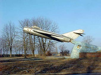 Abflug. Zurückgelassenes MIG Jagdflugzeug MIG 15 mit ausgebautem Triebwerk und aufgespießt auf einen Halteträger. Leider sind eine ganze Reihe Gebäude auf dem Flugplatz schon verschwunden, weil es da angeblich keine Verwendung für gab. Abflug. Zurückgelassenes MIG Jagdflugzeug MIG 15 mit ausgebautem Triebwerk und aufgespießt auf einen Halteträger. Leider sind eine ganze Reihe Gebäude auf dem Flugplatz schon verschwunden, weil es da angeblich keine Verwendung für gab.