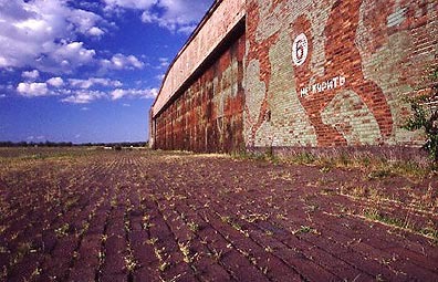 Flugzeughalle. Auf dem Fliegerhorst Werneuchen wurden ursprünglich neun große Hallen gebaut. Sieben davon waren Flugzeughallen. Eine Halle wurde als Waffenmeisterei genutzt und später von den Russen demontiert. Eine weitere Halle diente zum ""schärfen"" der Fliegerbomben. Diese Halle wurde 1945 gesprengt. Reste davon sind aber heute noch vorhanden. In frühen Jahren wurden einige der Flugzeughallen auch als Werftanlage der Lufthansa genutzt. Eine dieser alten Hallen ist inzwischen zu einer modernen Sporthalle umgebaut worden. Flugzeughalle. Auf dem Fliegerhorst Werneuchen wurden ursprünglich neun große Hallen gebaut. Sieben davon waren Flugzeughallen. Eine Halle wurde als Waffenmeisterei genutzt und später von den Russen demontiert. Eine weitere Halle diente zum ""schärfen"" der Fliegerbomben. Diese Halle wurde 1945 gesprengt. Reste davon sind aber heute noch vorhanden. In frühen Jahren wurden einige der Flugzeughallen auch als Werftanlage der Lufthansa genutzt. Eine dieser alten Hallen ist inzwischen zu einer modernen Sporthalle umgebaut worden.