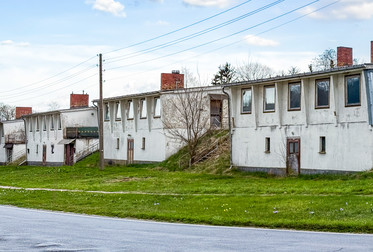 KRÖLBAU Mittelschiff mit zwei Seitenschiffen: Denkmalgeschütztes Ensemble aus vier weitgehend noch original erhaltenen Krölpalit-Gebäuden im brandenburgischen Wulkow, einem Ortsteil von Neuhardenberg. 1971/72 wurden sechs Krölpalit-Gebäude als Ersatzbauten für im Schloß Wulkow untergebrachte Familien errichtet. Das Schloß wurde zu einem Weiterbildungszentrum der VVB Maschinelles Rechnen umgebaut. Aufnahmedatum: 13.04.2025 © Thomas Born. Bild 9723