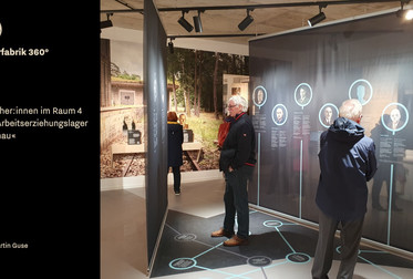 Besucher:innen im Raum 4 »Das Arbeitserziehungslager Liebenau«. Screenshot aus der Kurzdokumentation der Eröffnung. Sie ist Bestandteil der <a target="_blank" href="https://vimeo.com/tk360/vr-simulation-liebenau">Videosimulation zur VR-App »Pulverfabrik 360°«</a>. Aufnahmedatum: 05.11.2023 © Martin Guse. <span class="lightbox-bottom-description-additional"> Bildnummer: 9467, geladen am: 13.12.2023.</span> Bild 9467