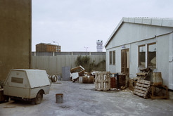 Scharnhorststraße in Berlin Mitte (Ost-Berlin), Hinterlandmauer mit Grenzturm, im Hintergrund Hafenspeicher in Berlin Tiergarten (West-Berlin), rechts DDR-Baracke, 15.06.1990 Bild 6664